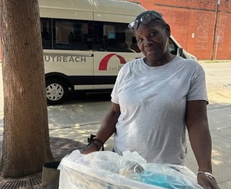 Woman holding laundry basket, as she moves into her new apartment.